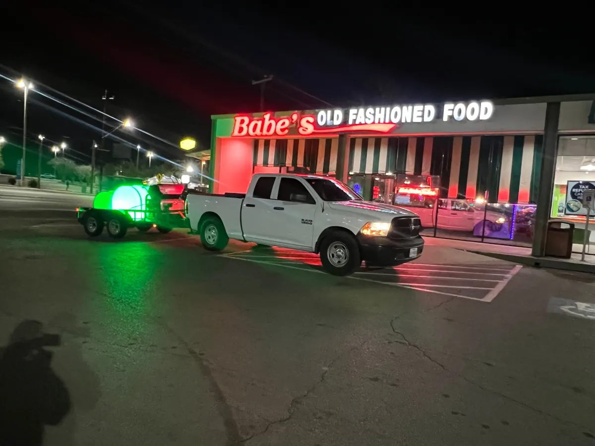 Service truck and pressure-wash trailer parked at Babe's Old Fashioned Food at night